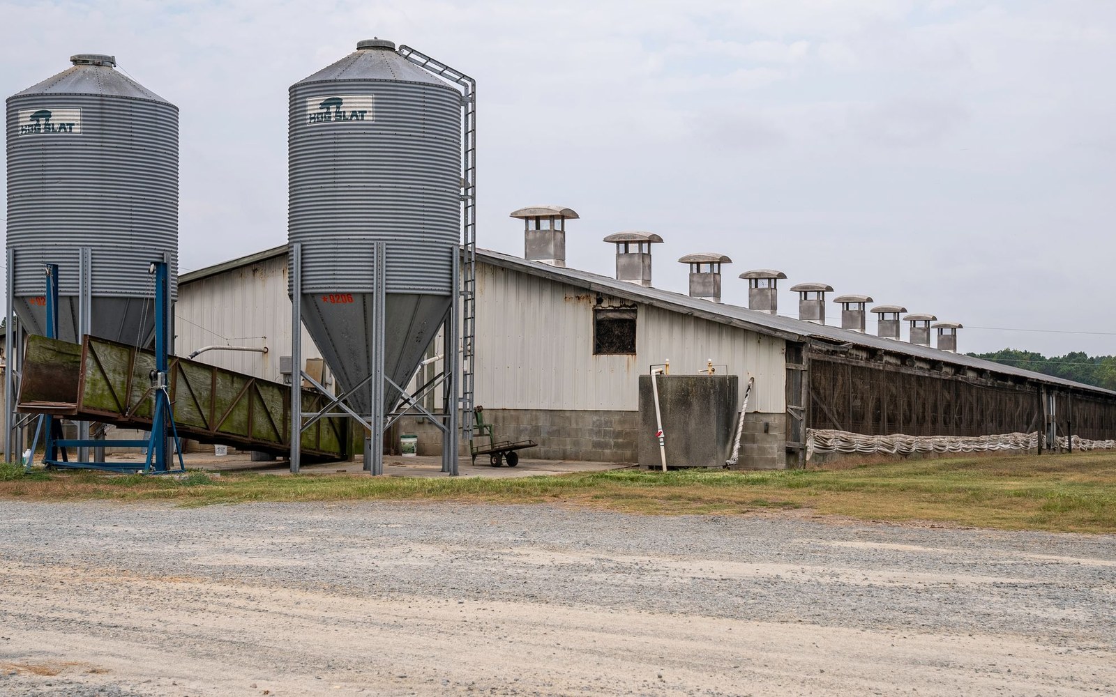 Large agricultural building and grain silos on a rural property